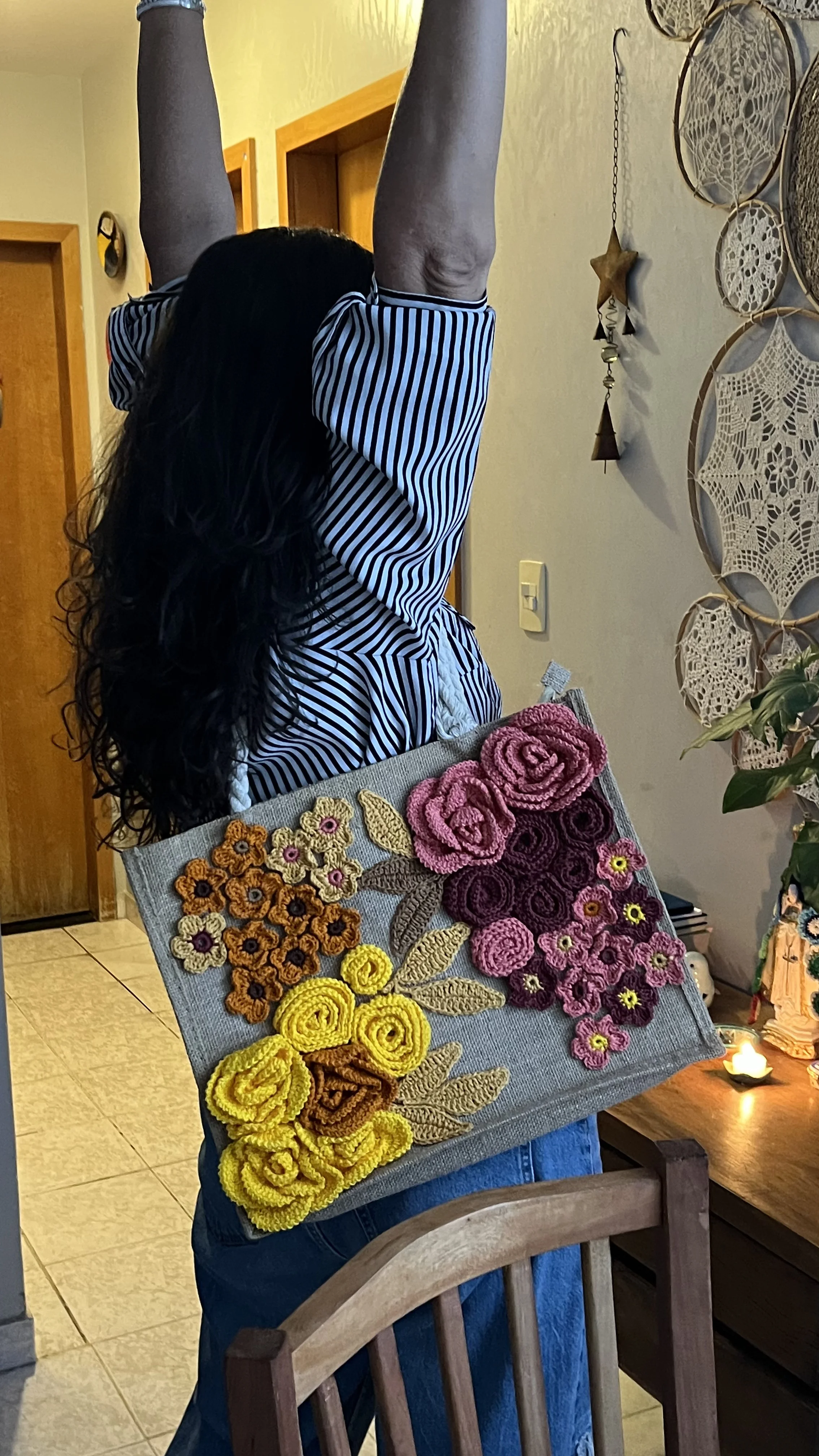 Bolsa cinza com flores em crochê, mostrando que o método funciona em qualquer bolsa