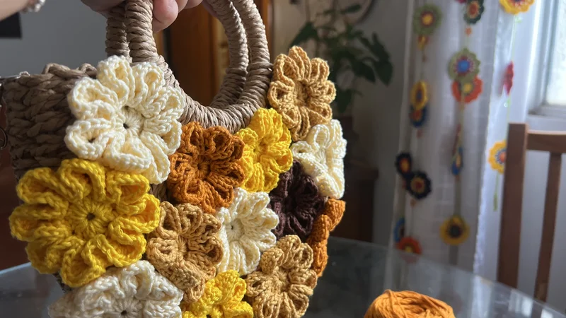Processo criativo inicial: Bolsa de palha lisa ao lado de novelos de linha de crochê