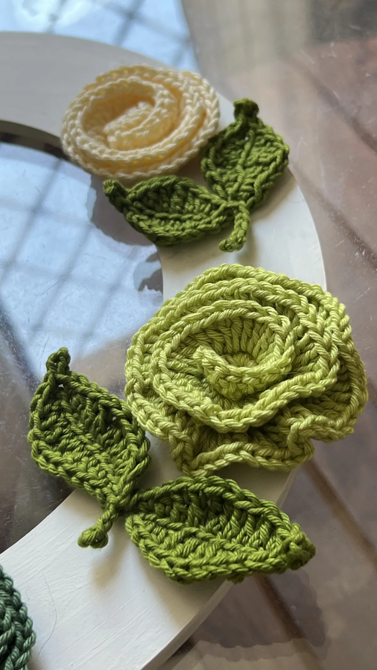 Flores Alice em crochê nas cores creme, verde-claro e verde-escuro com folhas